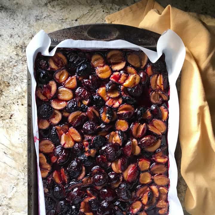 A large baking sheet with prunes that have been roasted.