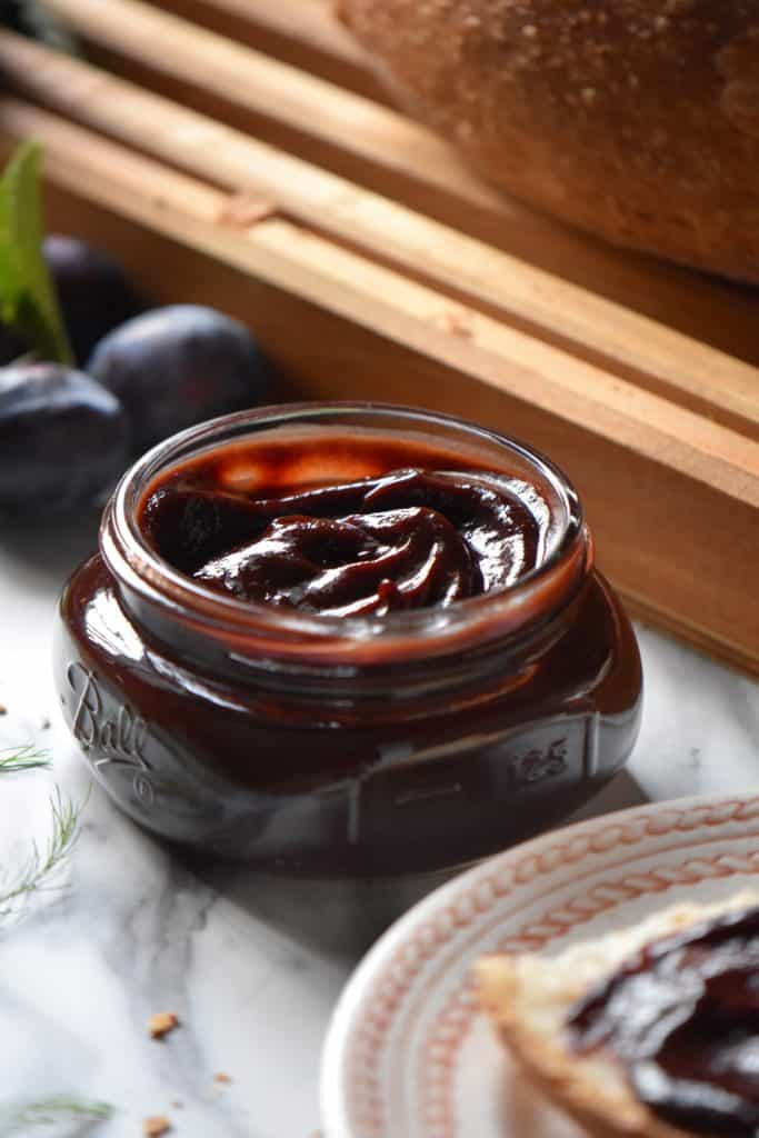 A close up shot of the swirls of the plum butter in a jar.