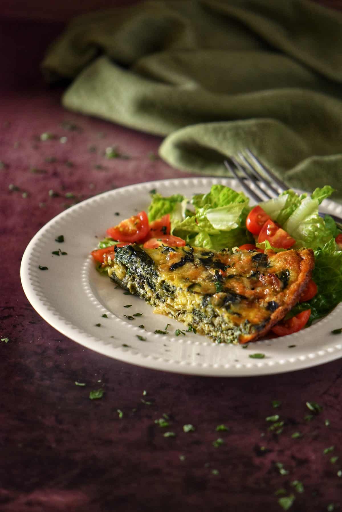 A slice of the spinach quiche on a plate.