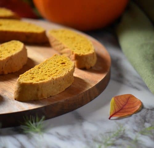 A few fall cookies, specifically pumpkin biscotti, on a wooden serving board.