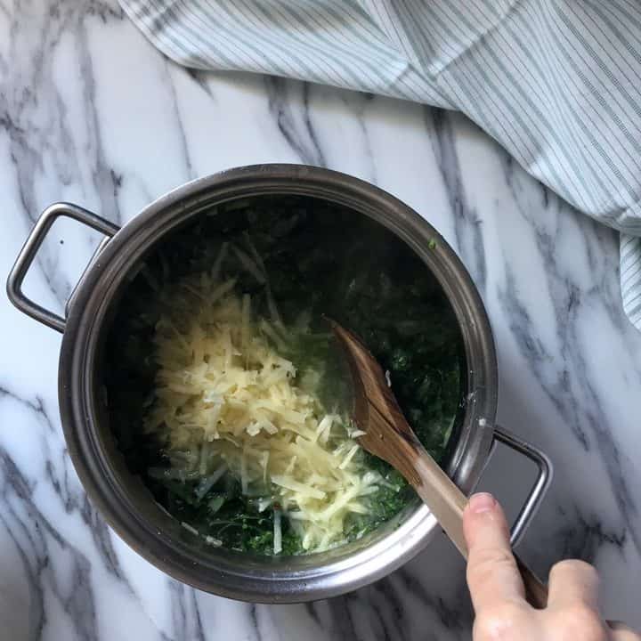 Grated potatoes added to the pot of Broccoli rabe soup.