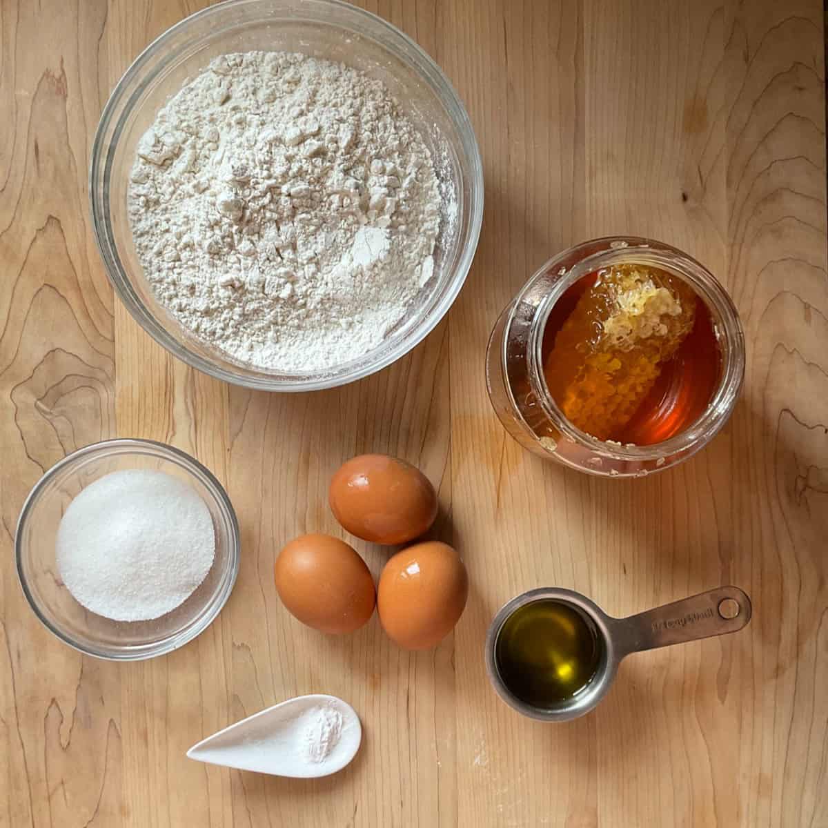 Ingredients to make Italian Honey cookies on a wooden board.