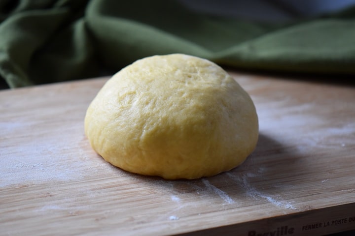 The dough to make Caragnoli on a wooden board.