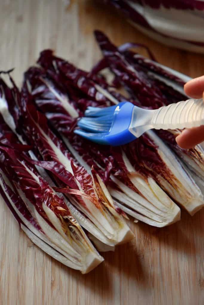 Olive oil is brushed on the radicchio sections before being grilled.