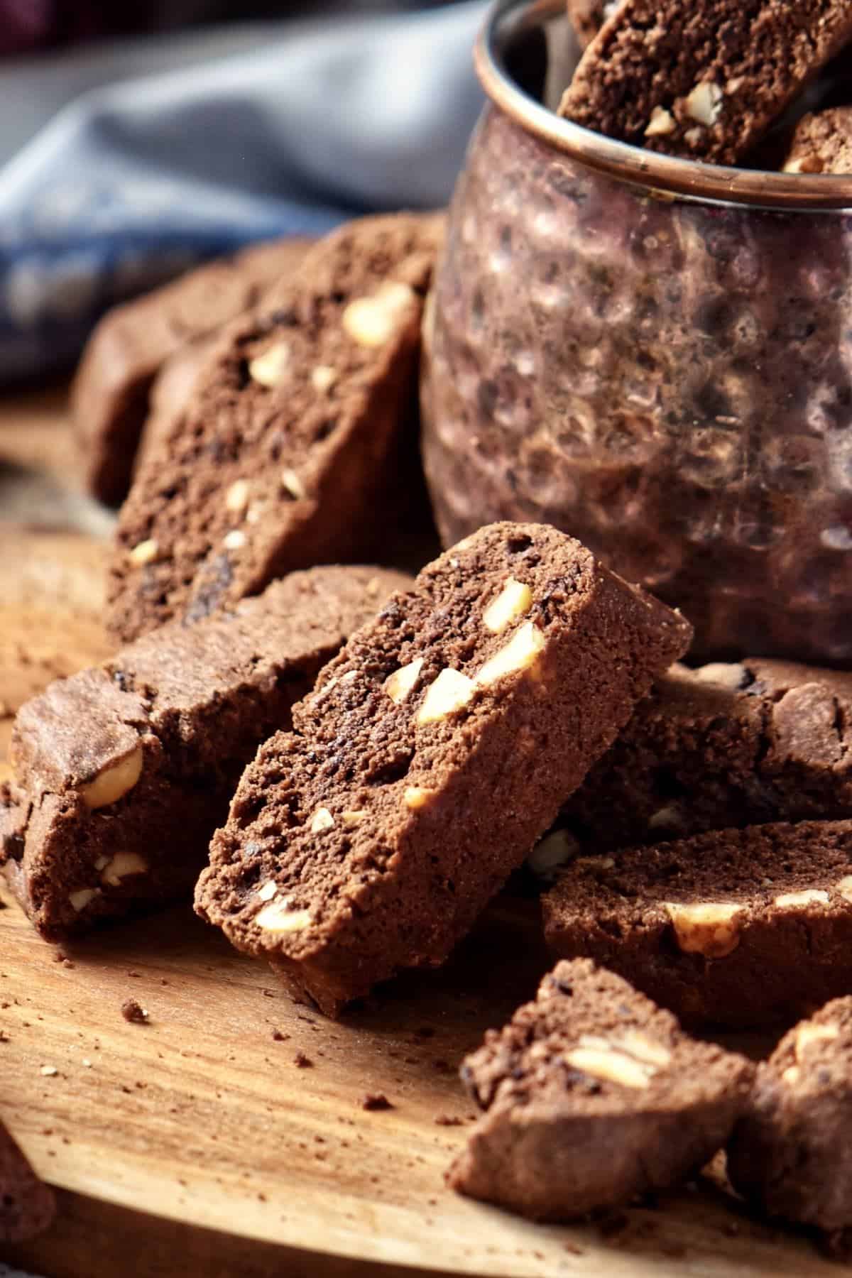 A pile of chocolate biscotti on a wooden board. 