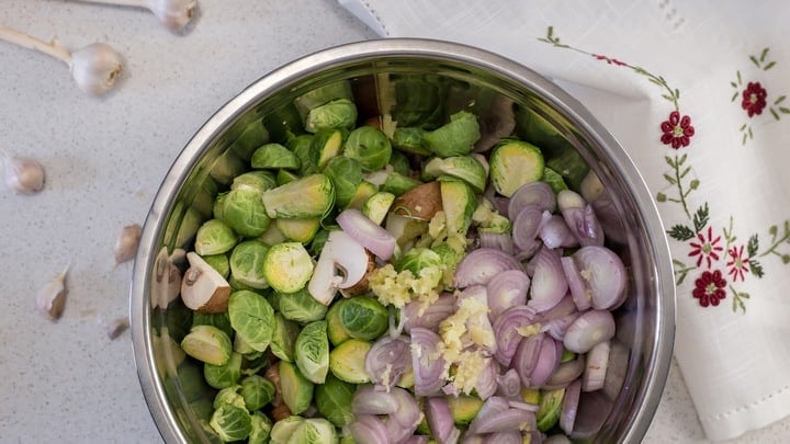 An overhead shot of the Brussels Sprouts, mushrooms, shallots and garlic in the process of being combined together.