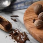 The final product of this allspice recipe can be seen scattered next to a wooden board.