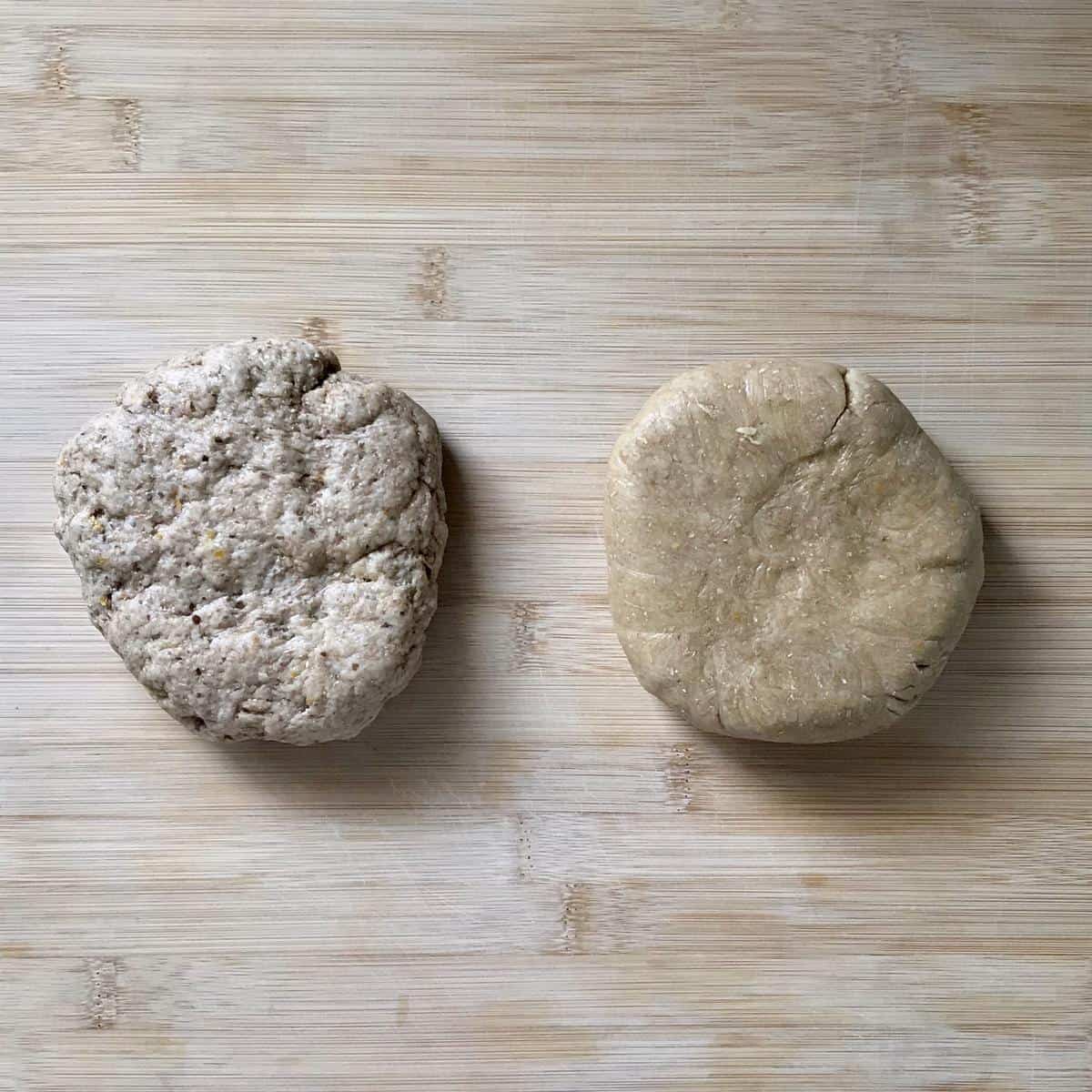 Two balls of cookie dough on a wooden board.