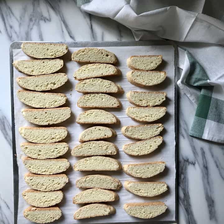 Sliced biscotti are placed on a parchment lined baking sheet.