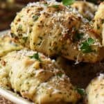 Garlic knots garnished with grated cheese and parsley.