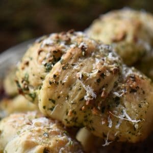 Garlic knots garnished with grated cheese and chopped parsley.