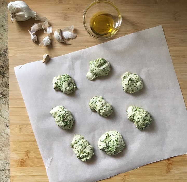 Garlic knots on a parchment paper, ready to be baked.