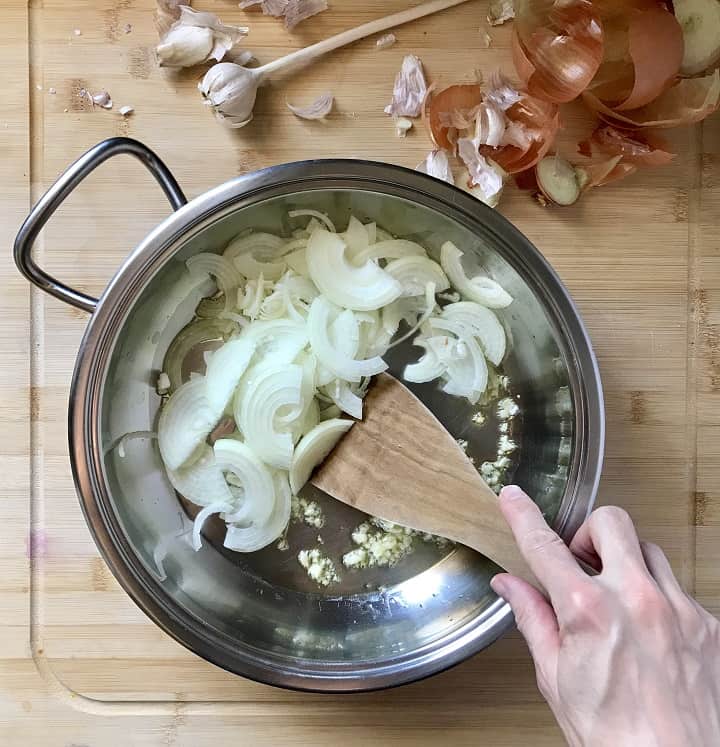 Sliced onions being sauteed with chopped garlic.