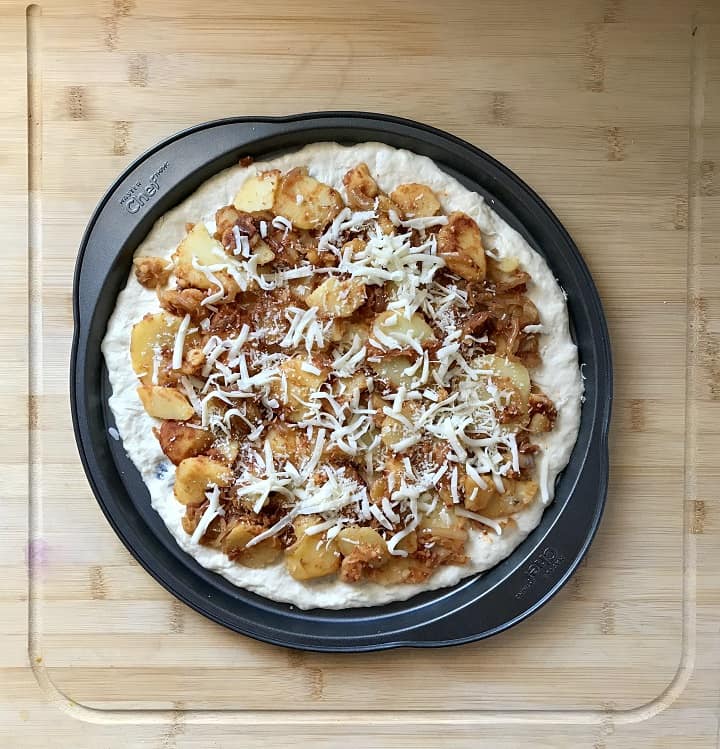 Grated mozzarella and Romano cheese used as a topping for a potato pizza.