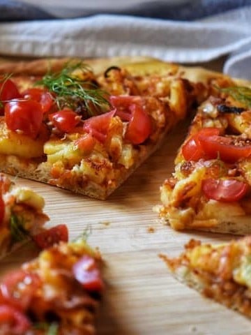 Pizza wedges of Potato pizza on a wooden board.