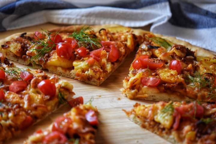 Pizza wedges of Potato pizza on a wooden board.