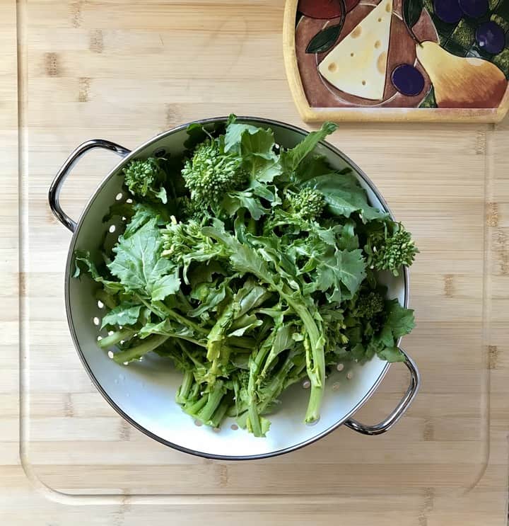 Broccoli rabe in a colander, about to be rinsed.