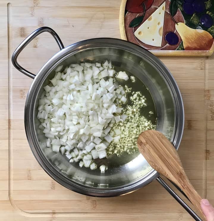 Chopped onions and garlic in teh process of being sauteed.