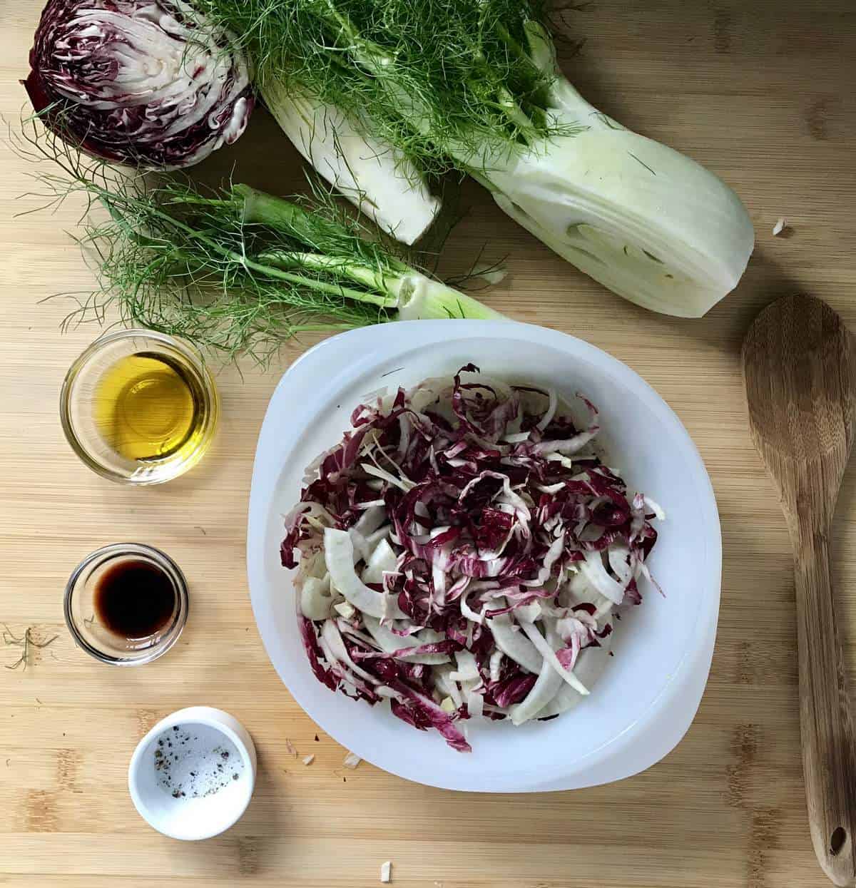 Thinly sliced endive, radicchio and fennel in a large mixing bowl.