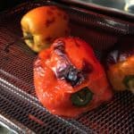 Bell peppers in an air fryer basket.