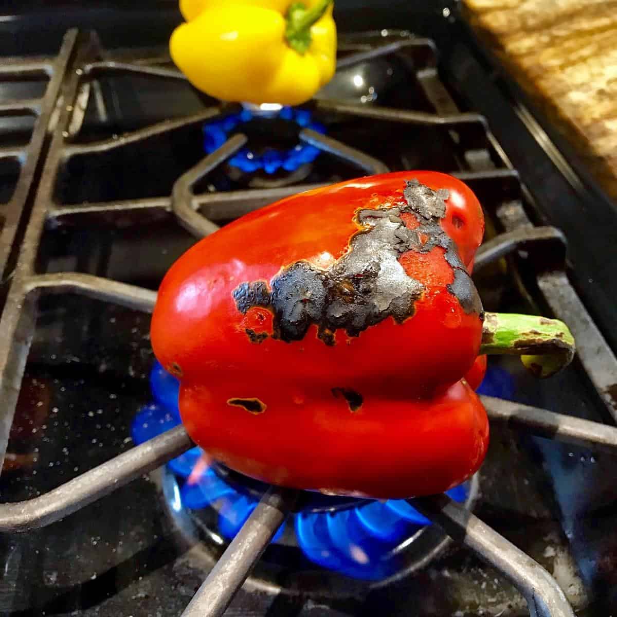 A pepper on a gas stove burner.