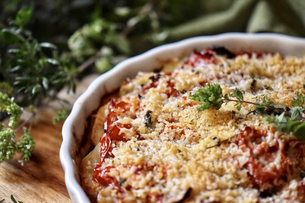 A close up of the surface of a potato and vegetable bake.