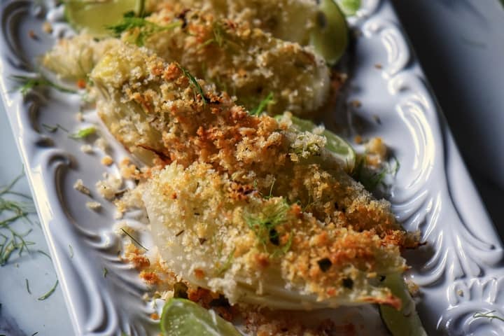 Oven baked fennel in a white dish.