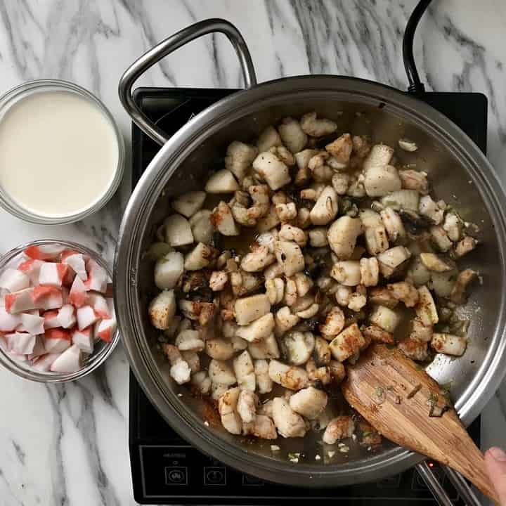 Shrimp is being sauteed in a large pan.