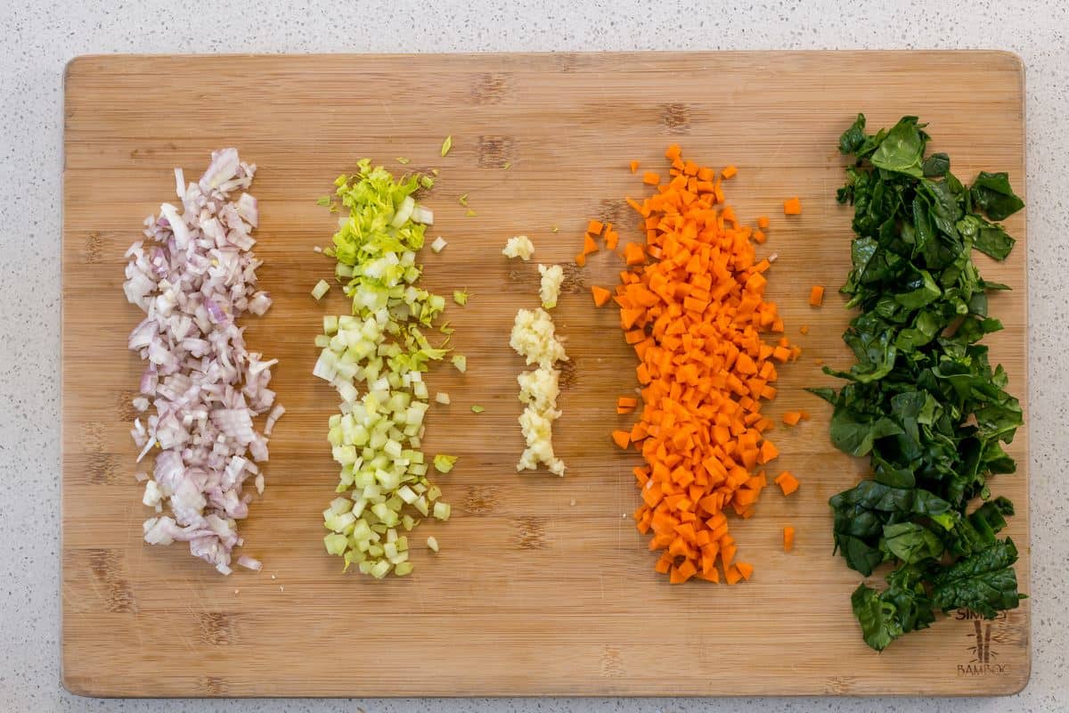 The vegetables to make a soffritto on a wooden board.