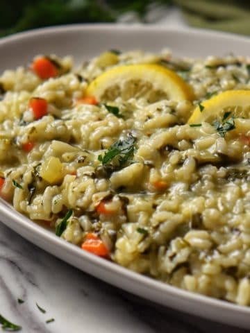 Spinach risotto in a white serving dish.