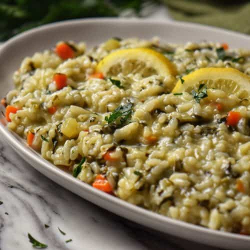 Spinach risotto in a white serving dish.