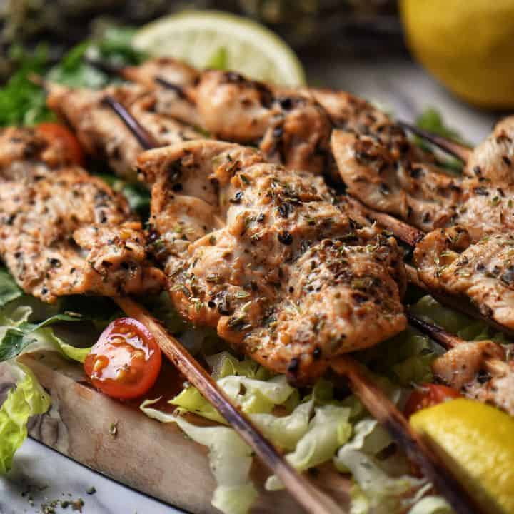 skewered pieces of chicken on wooden bamboo sticks.