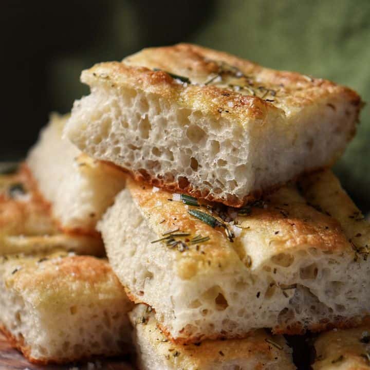 The soft texture and open crumb of focaccia bread is visible.
