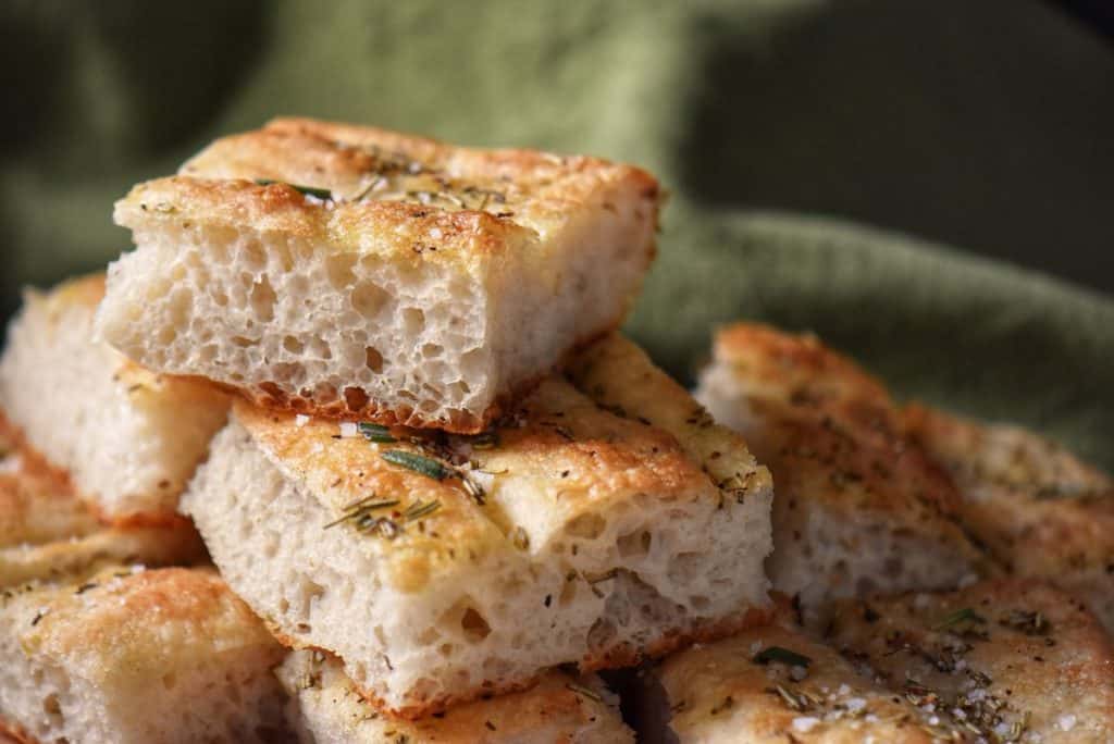 Square pieces of Italian focaccia piled on top of one another.