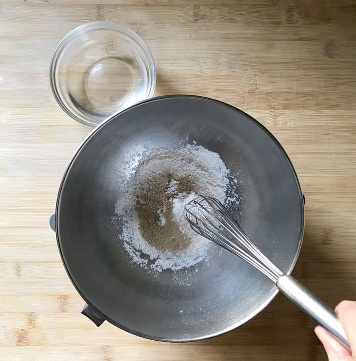 Dry active yeast and all purpose flour are being whisked on a bowl of a stand mixer.