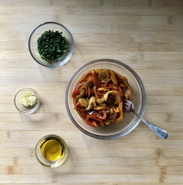 Olive oil, parsley, garlic and roasted peppers in individual bowls.