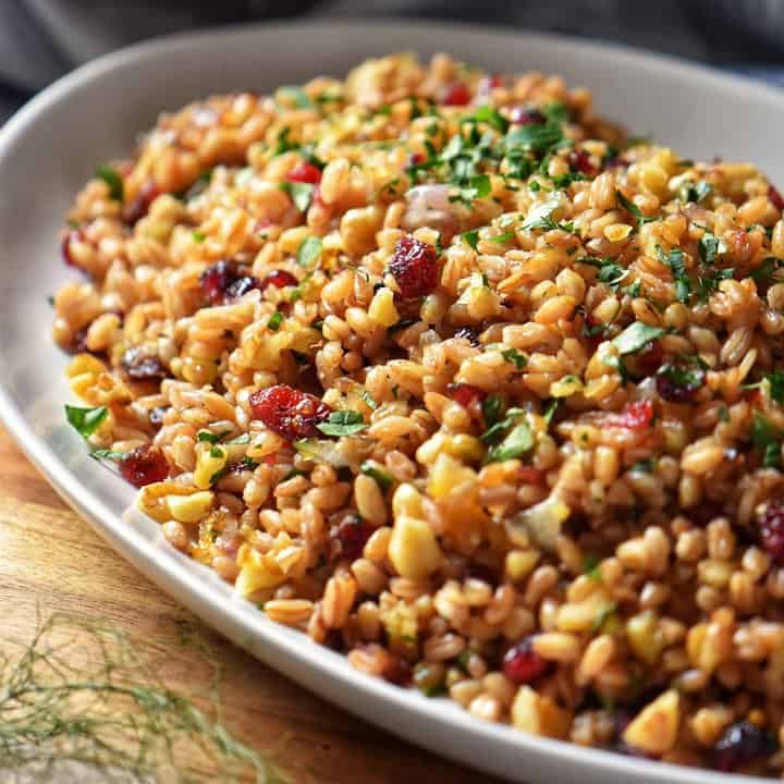 Warm farro salad, garnished with chopped parsley in a bowl.