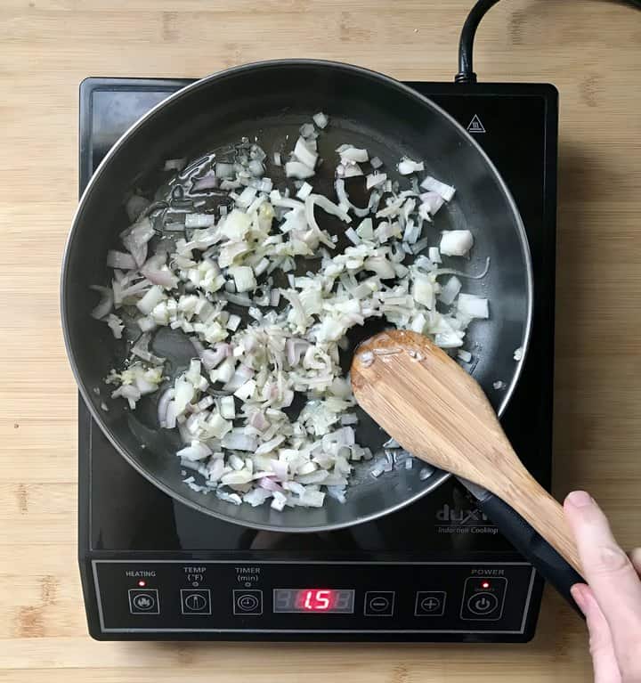 Shallots being sauteed in a pan.