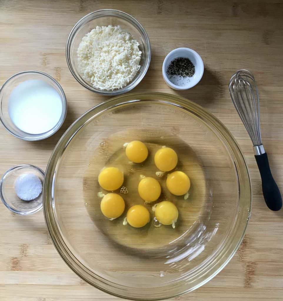 Some of the ingredients for the pasta pie are in bowls, ready to be combined.