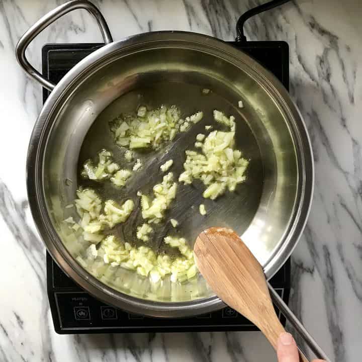 Onions are being sauteed in a saucepan.