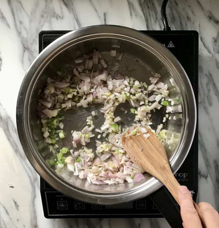 Green onions and french shallots are being sauteed.