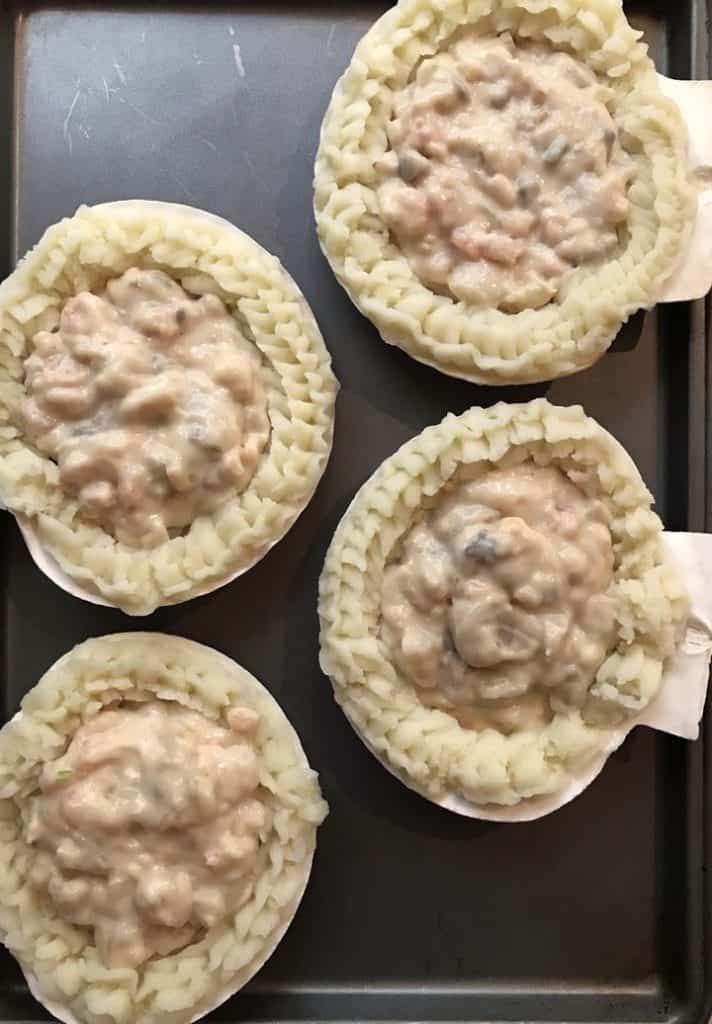 Scallop shells filled with the seafood mixture for Coquilles St-Jacques.