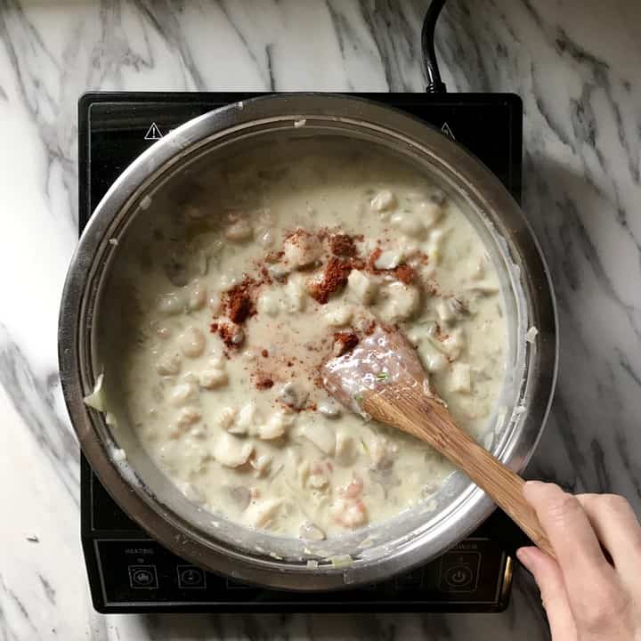 Paprika is being mixed in a seafood mixture.