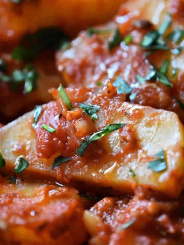 Potato wedges with tomato sauce and parsley.