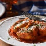 Italian stuffed pasta shells filled with meat and cheese and topped with chopped parsley.