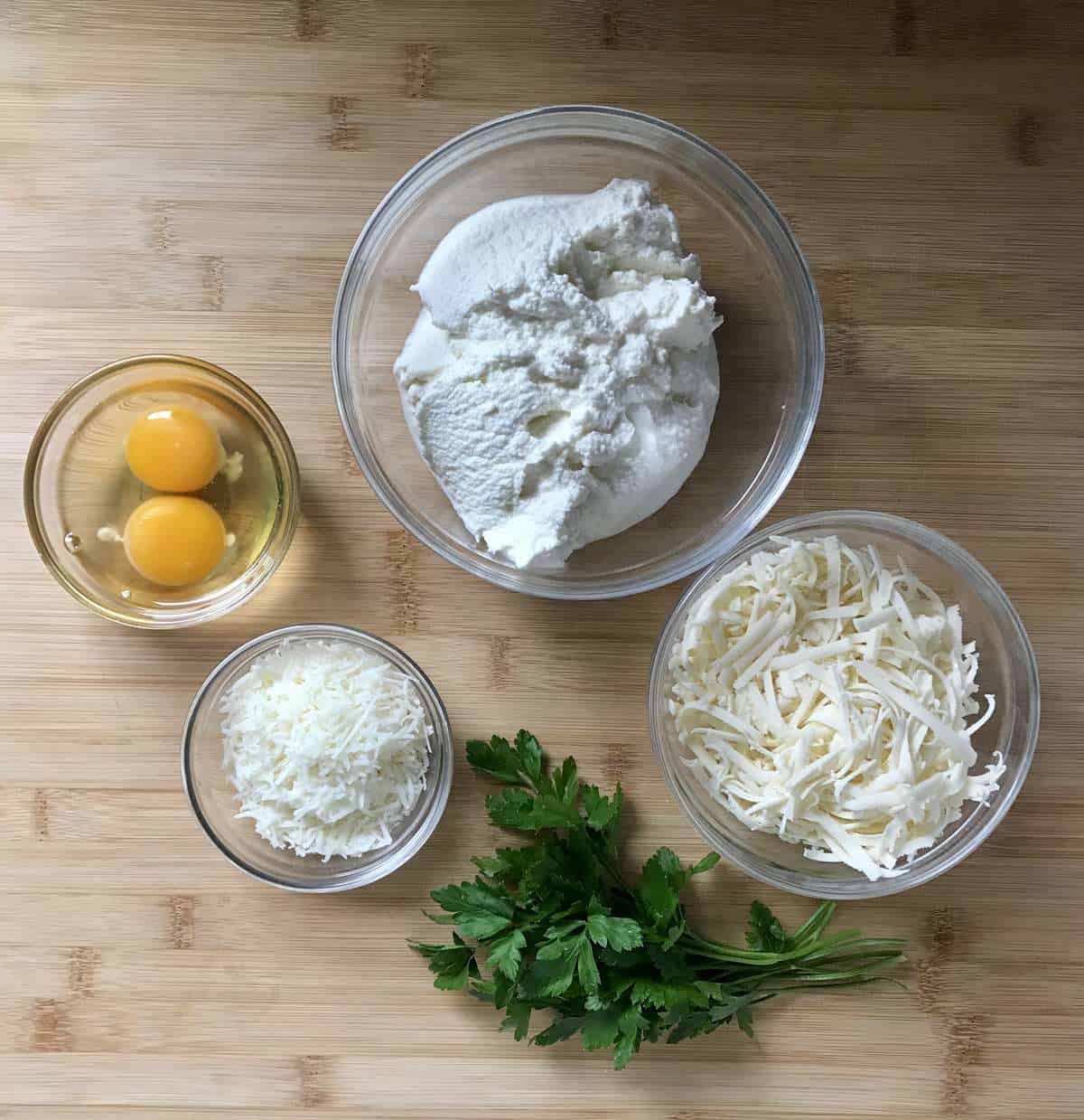 The measured ingredients to make the cheese mixture are placed in bowls.