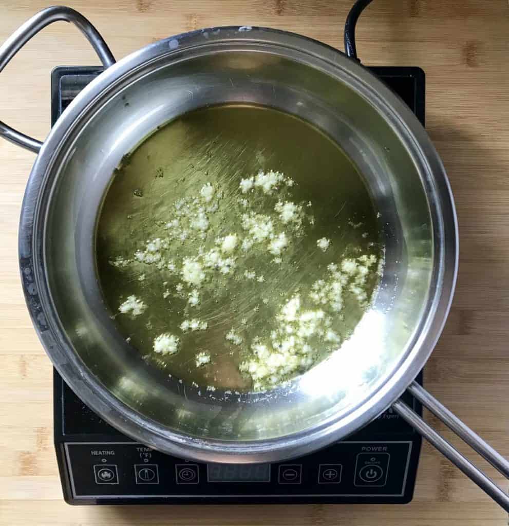 The chopped garlic is being sauteed in olive oil.