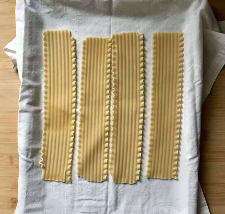 Lasagna noodles on a white tea towel.