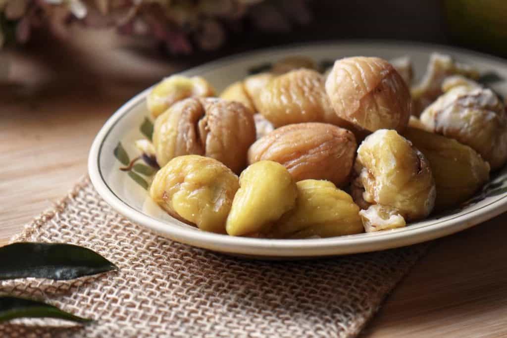 Boiled and peeled chestnuts on a serving dish. 