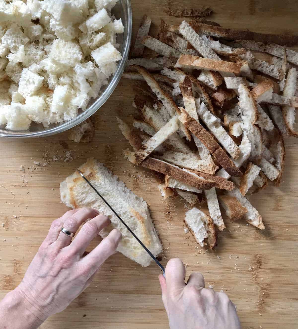 The crusts are being removed form a country style bread.